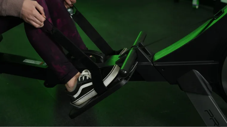 A person slipping into the ProForm 750R rowing machine's foot straps.