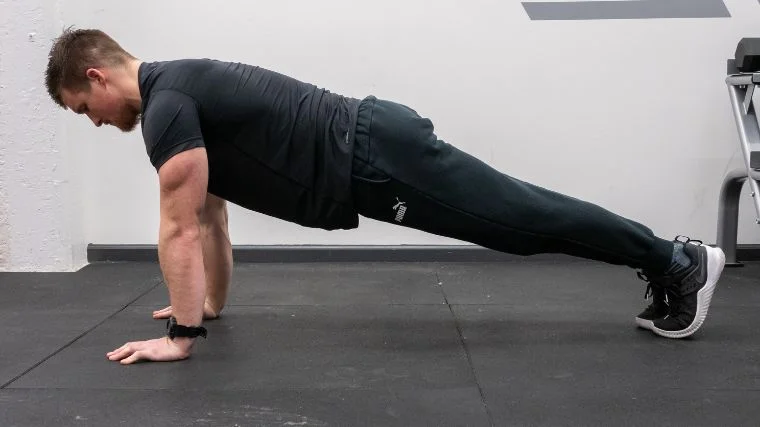 A coach doing pushups in the gym.