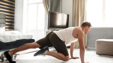 A person performs mountain climbers while working out in a hotel room.