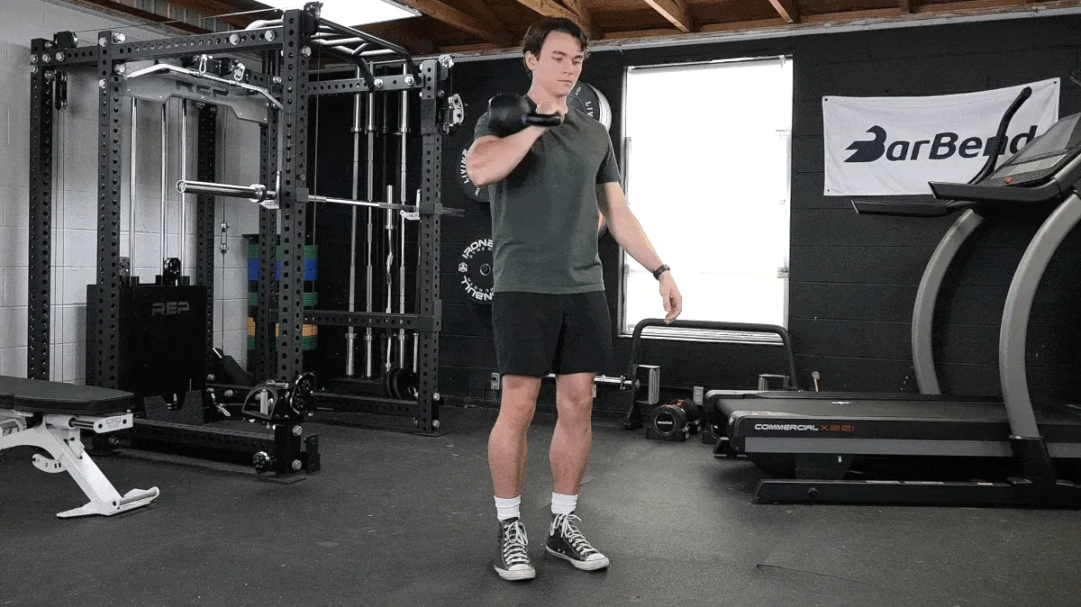A person performing the Single-Arm Kettlebell March and Reverse Lunge.