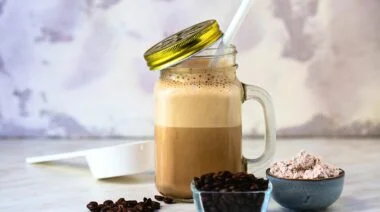 A cup of coffee, coffee beans, and pre-workout.
