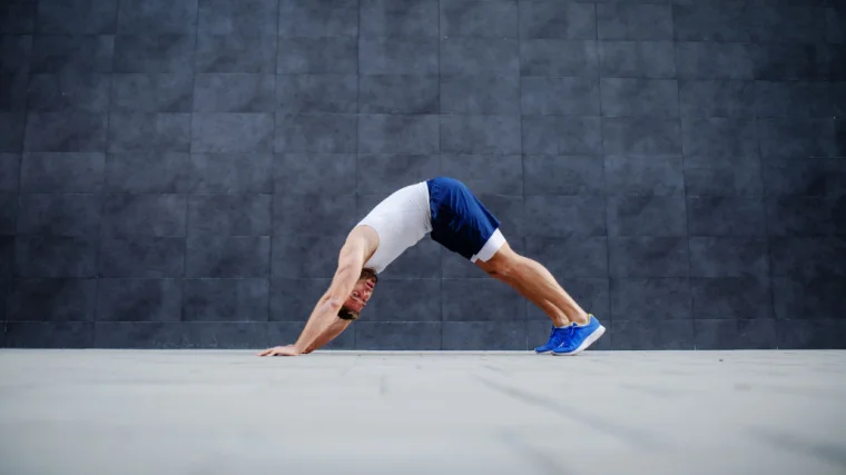 Side view of a fit person doing inchworm exercise.
