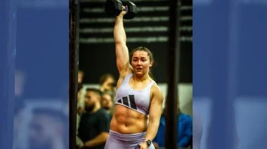 Jennifer Muir triumphantly holds up a dumbbell.