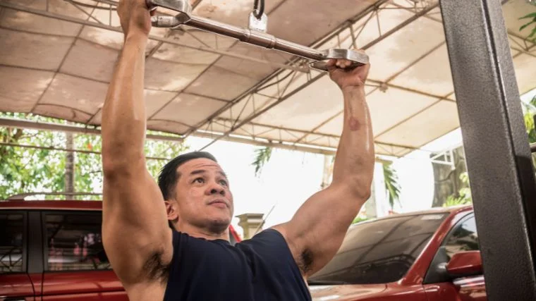 A bodybuilder doing neutral-grip pulldowns.
