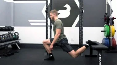 A person performing the bodyweight Bulgarian split squat.
