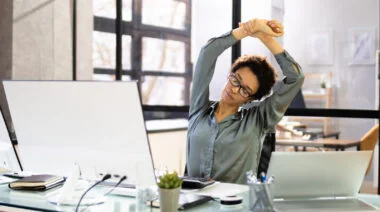 A person stretching in the desk inside the office
