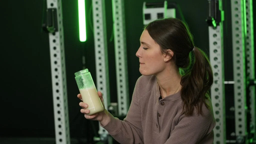 A person looks at their protein shake between sips.