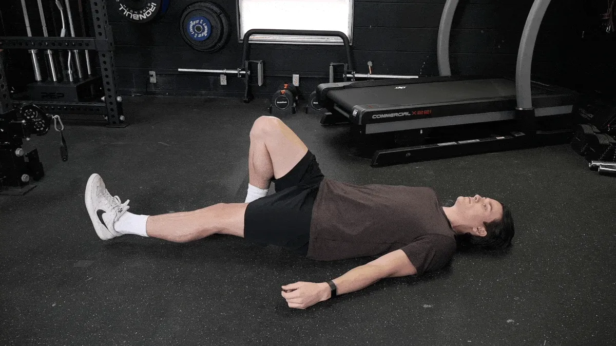 A person performing the single leg lying leg raise exercise.
