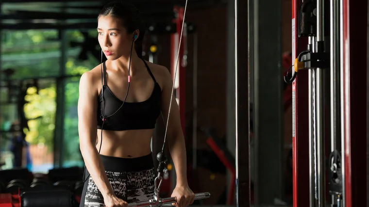 A person exercises with cables in the gym.