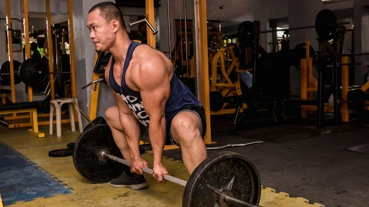A bodybuilder starting to do a sumo deadlift.