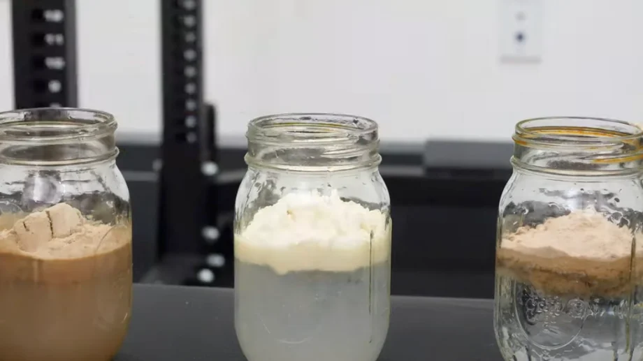 Three jars with different Optimum Nutrition Whey Protein flavors.