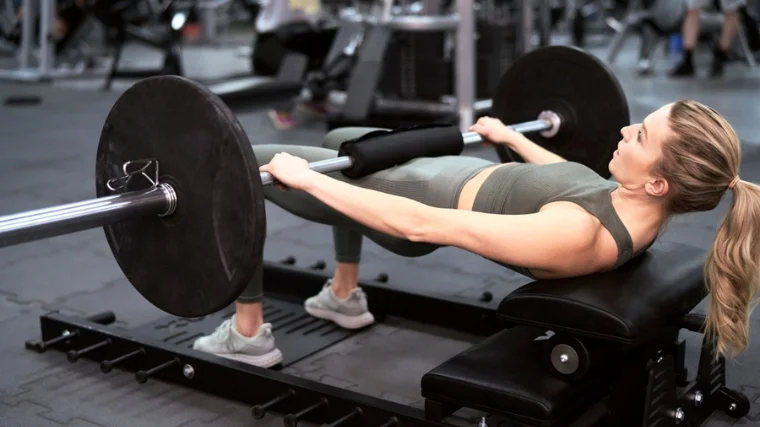 A person doing a barbell hip thrust.