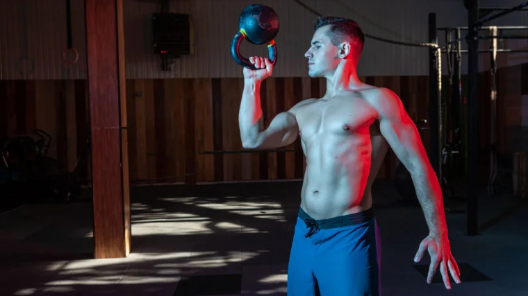 An athlete exercising with a kettlebell with the bottom up.