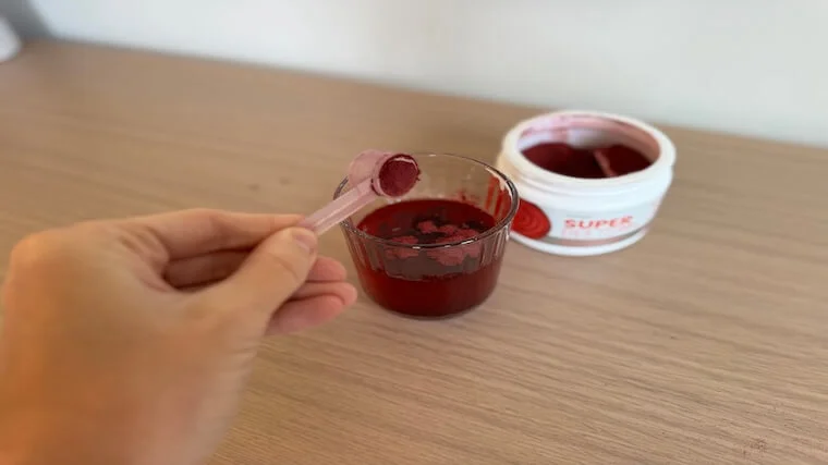 Our tester adding a scoop of HumanN SuperBeets powder to a glass of water