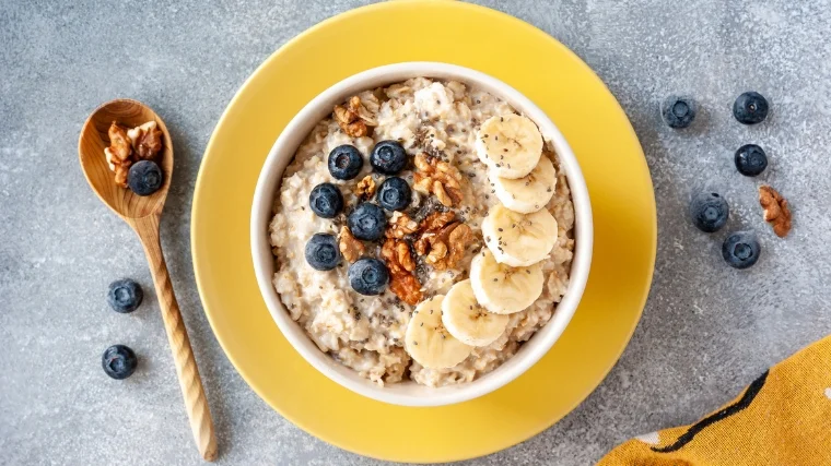 A bowl of oatmeal with fruits.