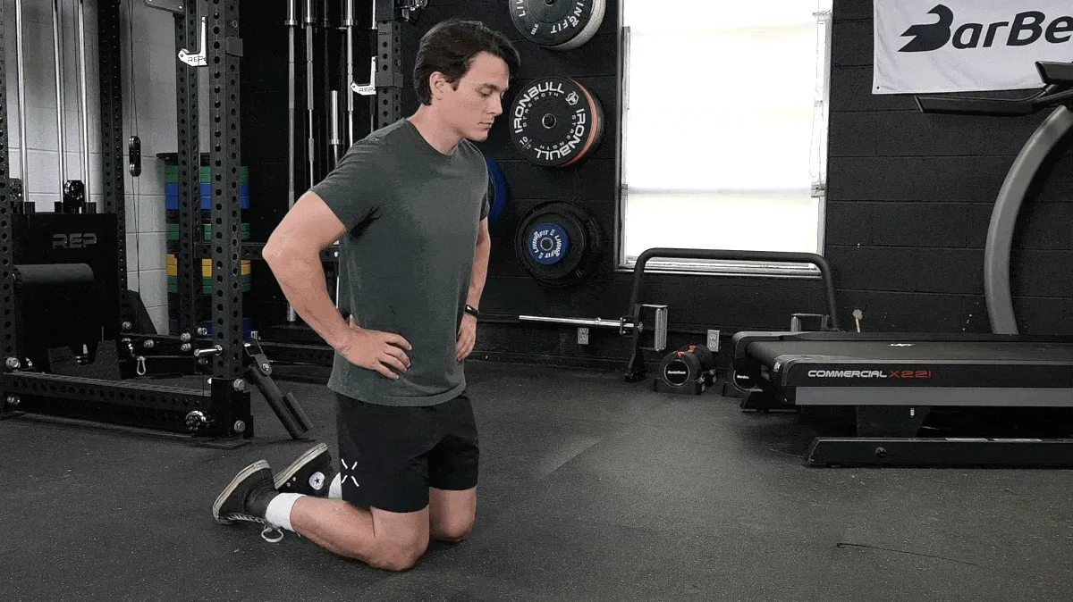 A person doing the half-kneeling quad stretch.