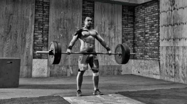 MAn performing a snatch exercise using a hook grip