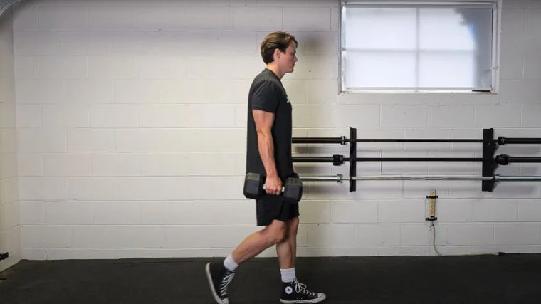 A person performing the farmer's carry exercise.