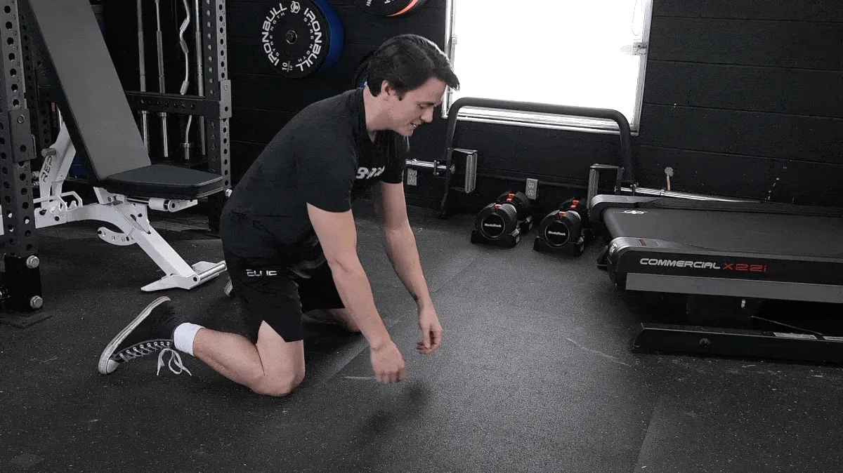 BarBend's Jake Herod performing the frog pose exercise.