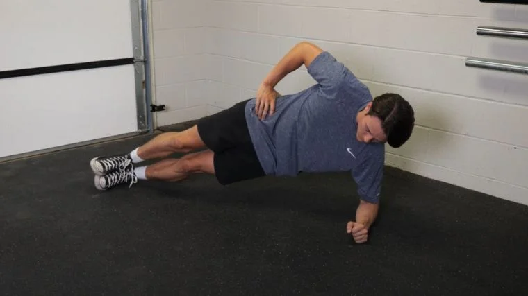 A person performing the side plank exercise.