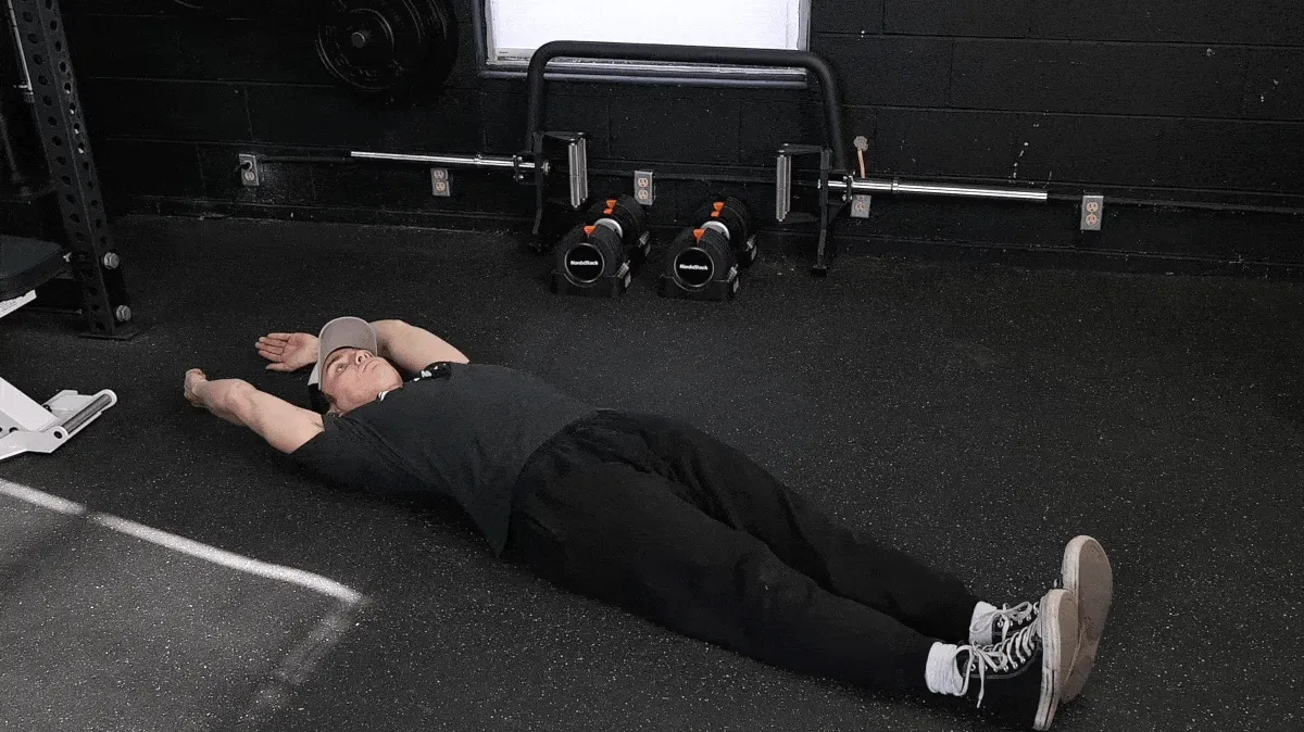 BarBend's Jake Herod performing the hollow hold exercise.