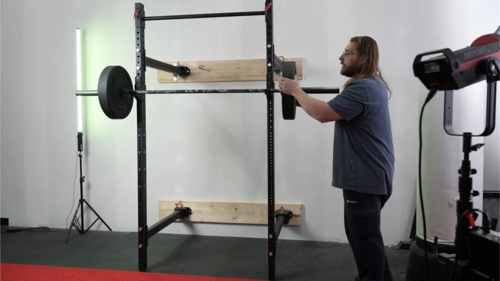 Person loading barbell on Titan T3 folding rack