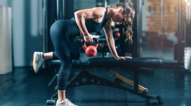 A person doing the three point row kettlebell exercise.