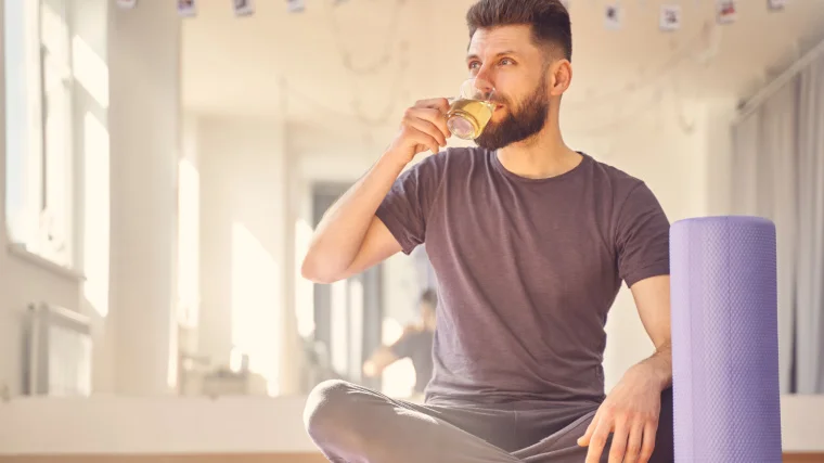 A person sitting on the floor drinking tea.
