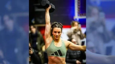 Ella Wilkinson holds up a dumbbell at a competition