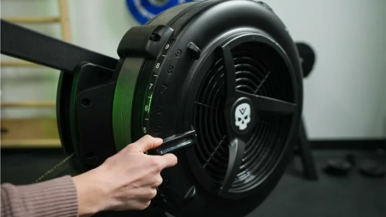Our tester adjusting the resistance on the Vulcan Scull Rower.