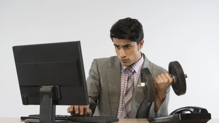 A person doing exercise with a dumbbell while working