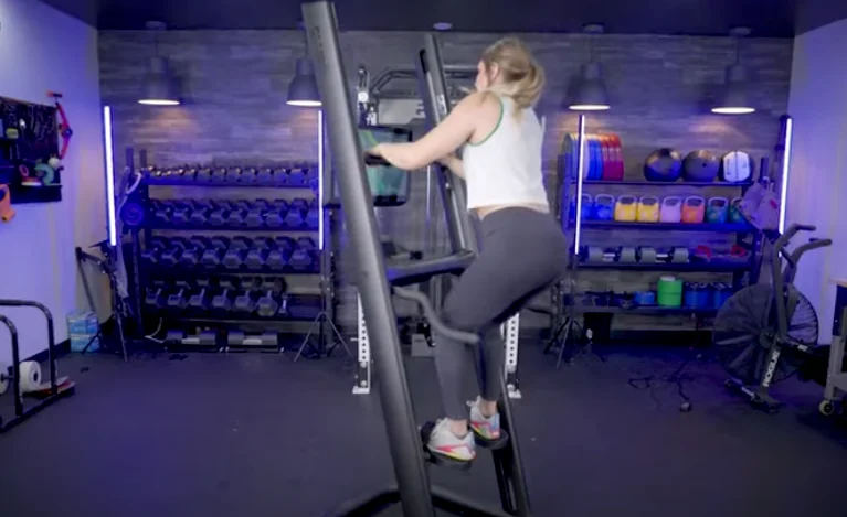 A woman working out with the CLMBR Connected 02 equipment.