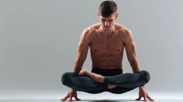 A shirtless muscular person doing yoga.