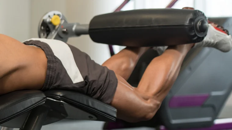 Leg curls slowly extending on the machine
