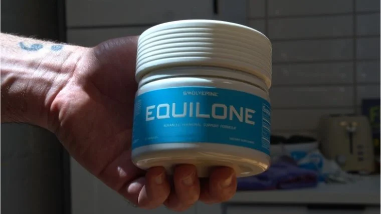 A person holding a container of Swolverine Equilone