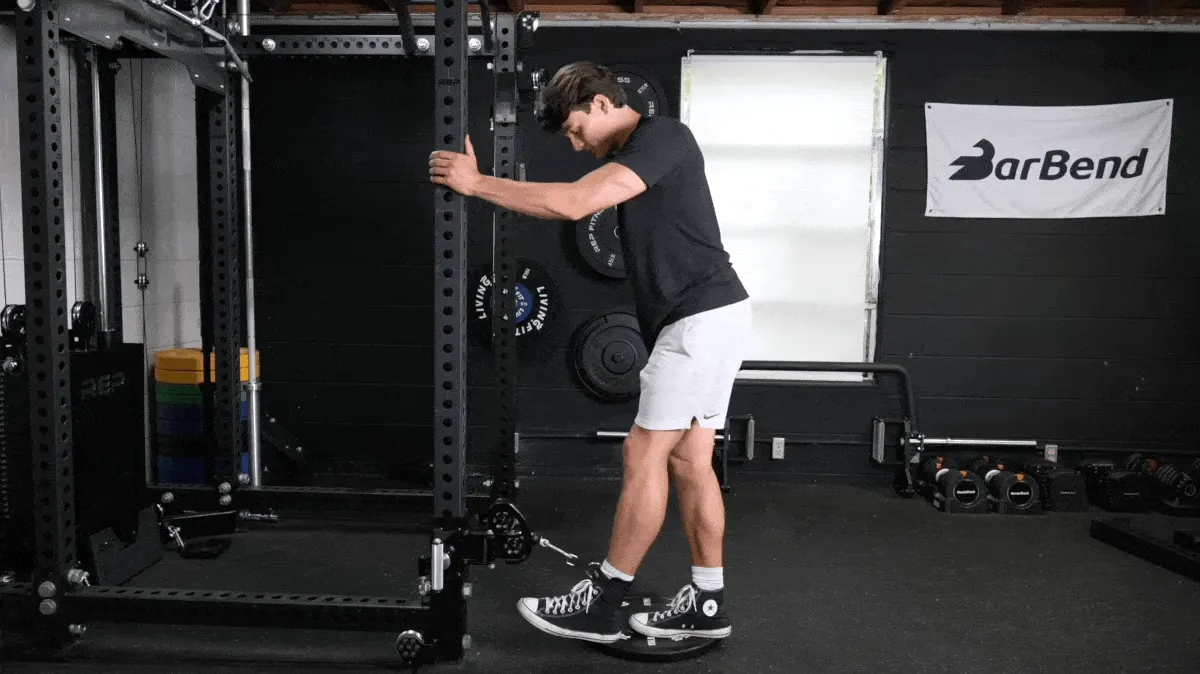 BarBend's Jake Herod performing the cable glute kickback exercise.