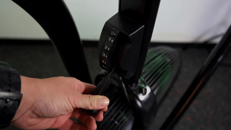 Our tester adjusting the Xebex AirPlus Performance Bike's magnetic resistance system