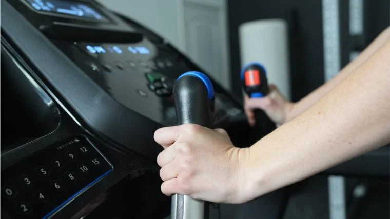a person gripping the handles of the Horizon 7.0 AT Treadmill