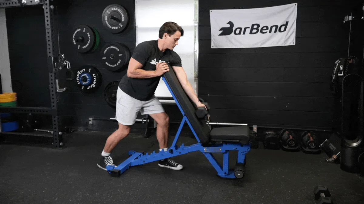 A person performing the arm-over bench preacher curl exercise.