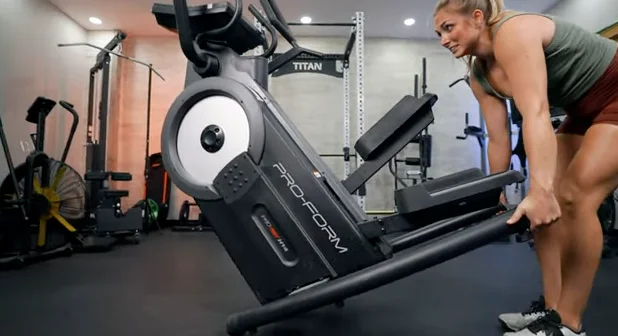 A person tipping the ProForm Pro HIIT H14 stair-stepping machine.