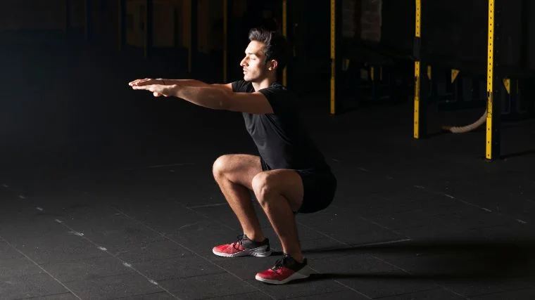 A person doing squats in the gym.