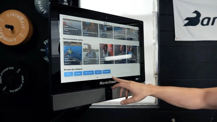 A BarBend tester browsing the iFIT library available through the NordicTrack RW900 Rower