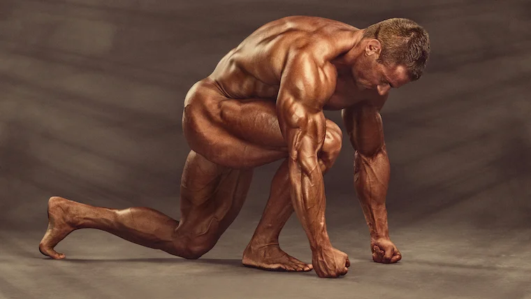 Handsome,,Muscular,,Naked,Bodybuilder,Kneeling,On,The,Floor,,Flexing,Muscles