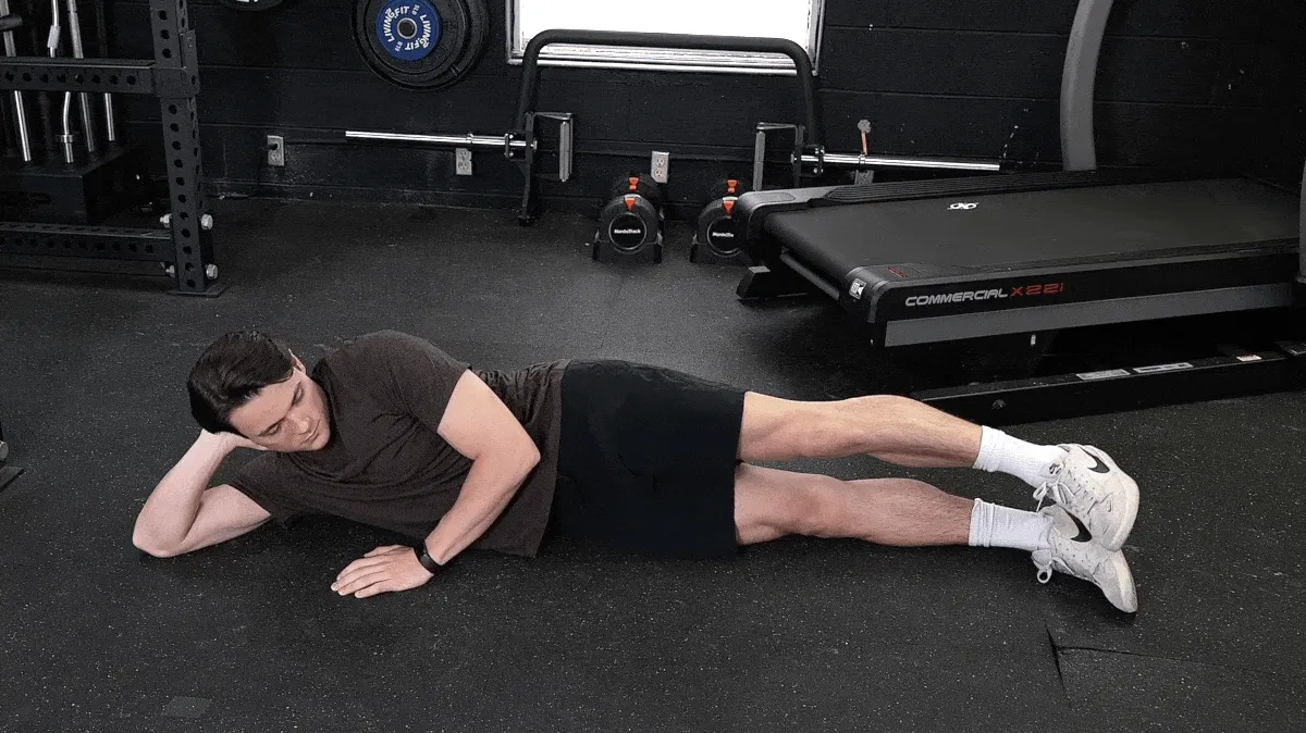A person doing the side leg raise exercise.