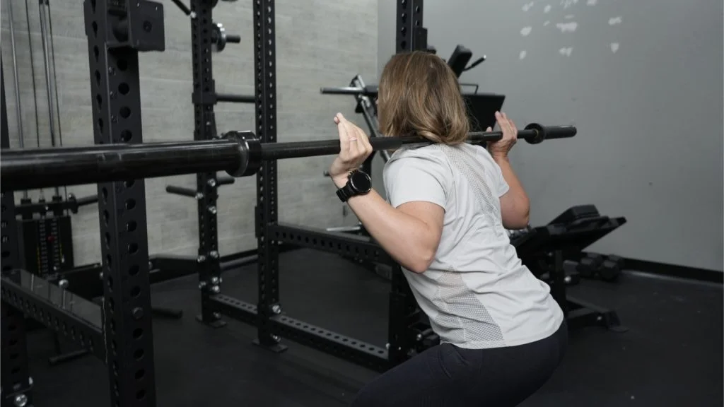 A person squatting using the Bells of Steel Manticore Squat Rack.
