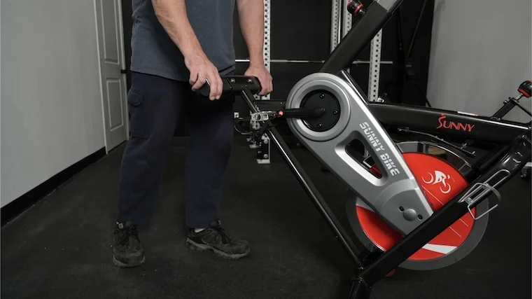Our tester moving the Sunny Health and Fitness SF-B1002 exercise bike into position for a workout