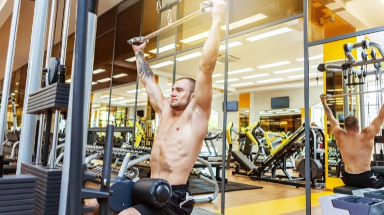 An athlete grabbing the lat pulldown bar with a neutral grip.