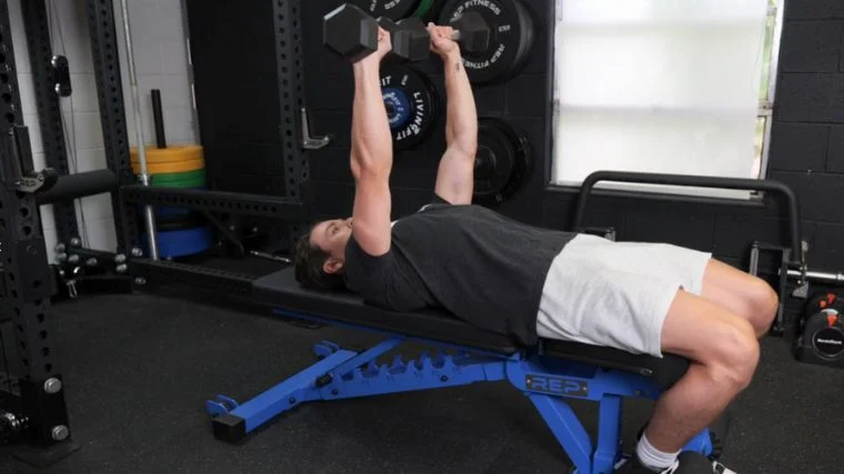 BarBend's Jake Herod performing the dumbbell bench press.