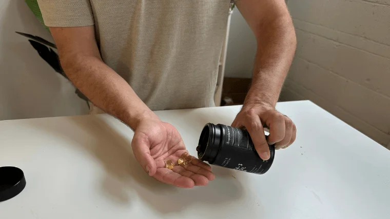 Our tester pouring Sports Research Omega-3 capsules into their hand