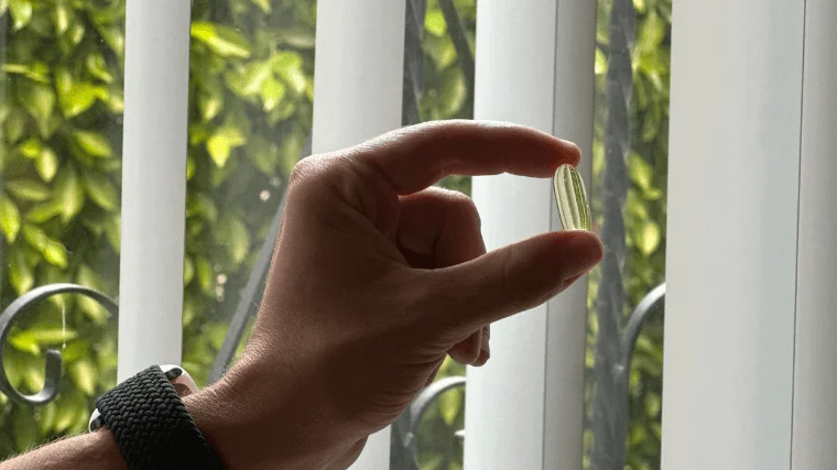 Our tester holding a single Nutricost Fish Oil capsule